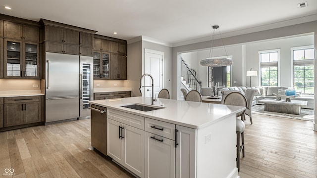 12099 Sigillary Way, Carmel, IN 46032 - kitchen featuring appliances with stainless steel finishes, light wood-type flooring, recessed lighting, ornamental molding, and light countertops