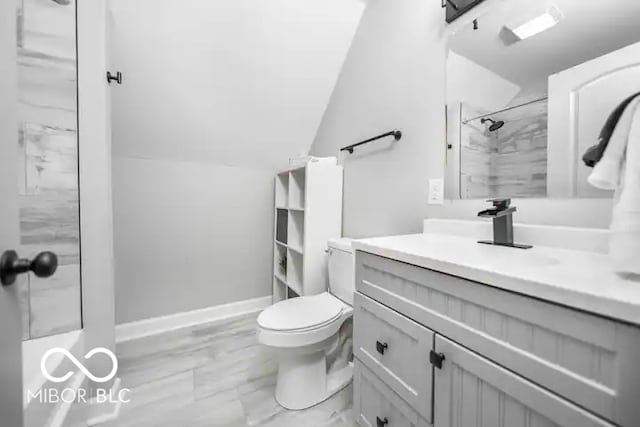 1444 English Ave, Indianapolis, IN 46201 - bathroom with vanity, walk in shower, toilet, lofted ceiling, and marble finish floor