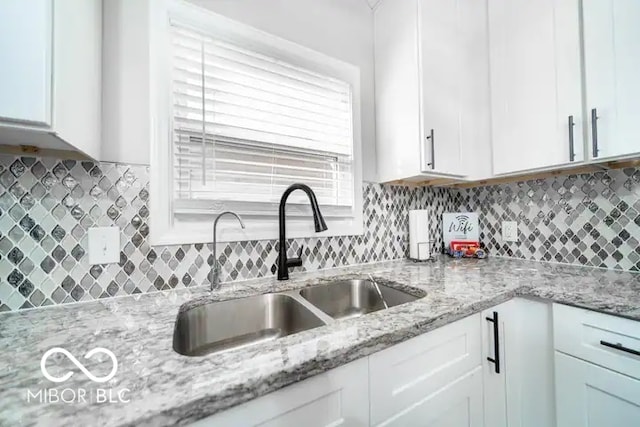 1444 English Ave, Indianapolis, IN 46201 - kitchen featuring white cabinets, a sink, and backsplash