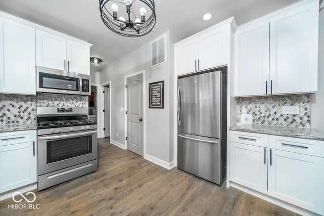 1444 English Ave, Indianapolis, IN 46201 - kitchen with decorative backsplash, a notable chandelier, visible vents, and stainless steel appliances