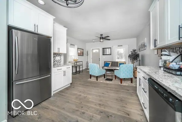 1444 English Ave, Indianapolis, IN 46201 - kitchen with light wood-type flooring, light stone counters, white cabinetry, ceiling fan, and appliances with stainless steel finishes