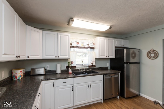 251 Howard Rd, Greenwood, IN 46142 - kitchen with white cabinets, a sink, stainless steel appliances, and wood finished floors