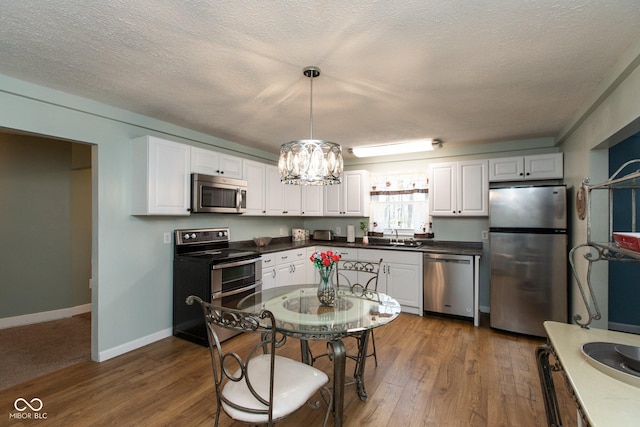 251 Howard Rd, Greenwood, IN 46142 - kitchen with a sink, white cabinetry, appliances with stainless steel finishes, and dark wood-type flooring