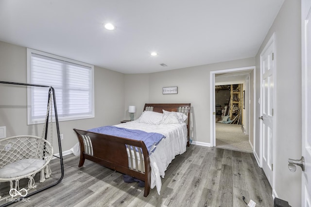 bedroom featuring baseboards, light wood-style flooring, and recessed lighting