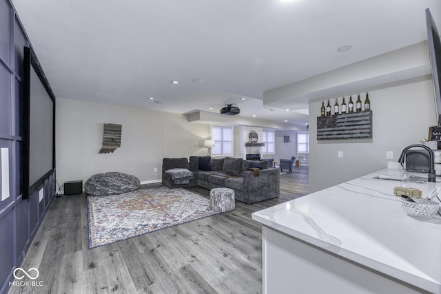 living area featuring light wood-style flooring, baseboards, and recessed lighting