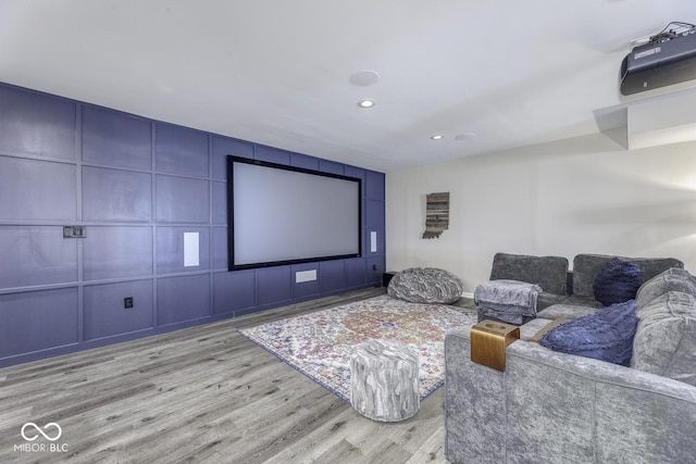 home theater room with a decorative wall, recessed lighting, and wood finished floors