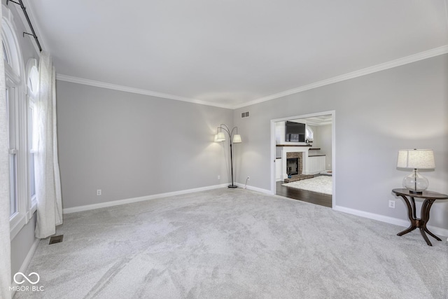 unfurnished living room featuring baseboards, carpet floors, ornamental molding, and visible vents