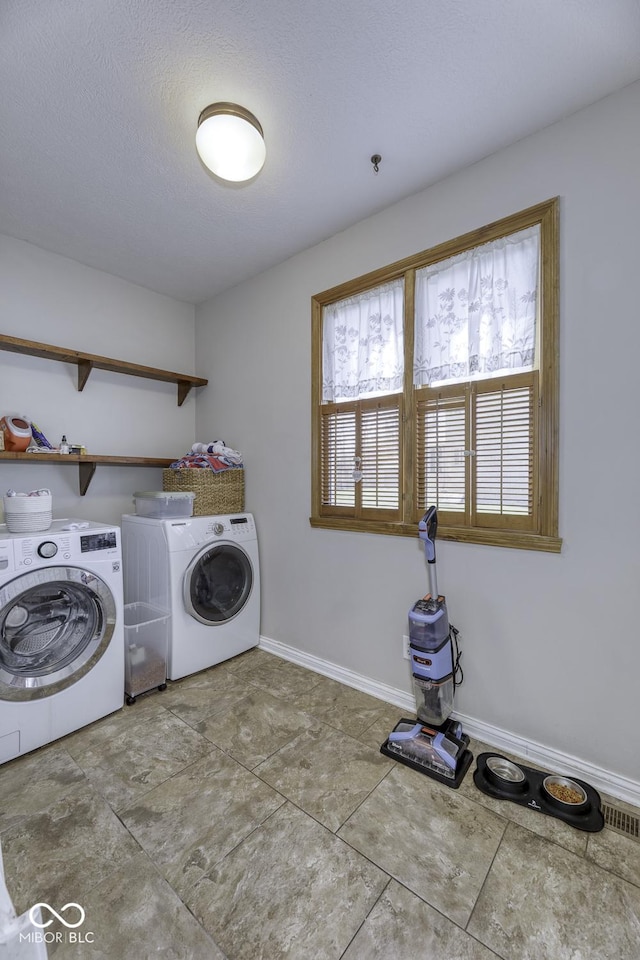 laundry area with washing machine and dryer, baseboards, laundry area, and visible vents