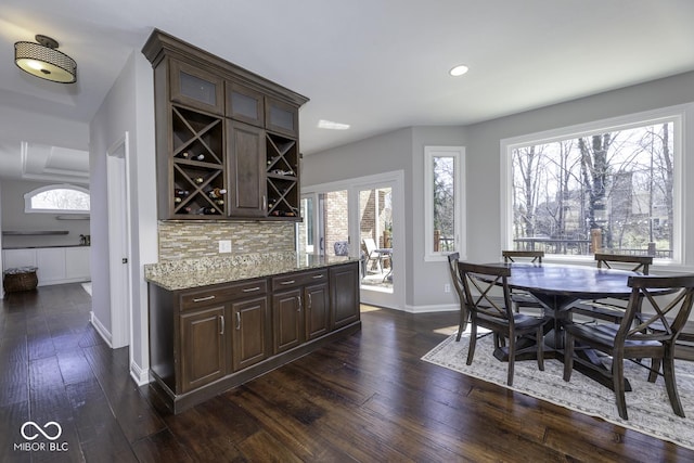dining space with baseboards, a dry bar, recessed lighting, and dark wood-style flooring
