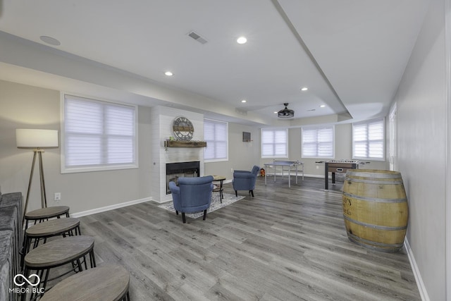 living area featuring baseboards, visible vents, recessed lighting, and wood finished floors
