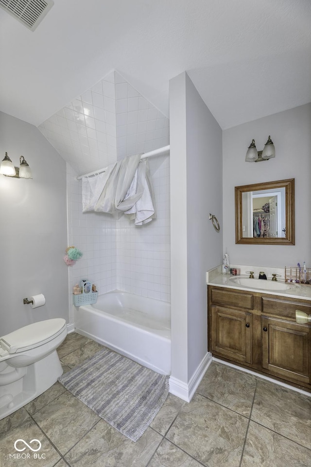 bathroom with vanity, lofted ceiling, toilet, baseboards, and visible vents