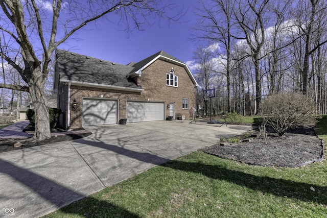 view of side of property featuring roof with shingles, a garage, brick siding, and concrete driveway