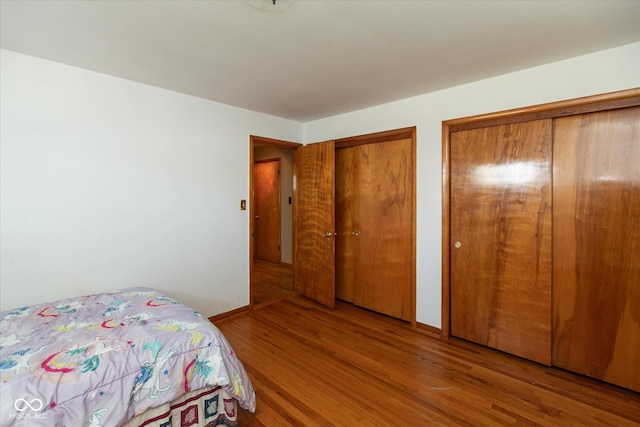817 Shadowlawn Ave, Greencastle, IN 46135 - bedroom featuring baseboards, two closets, and wood finished floors
