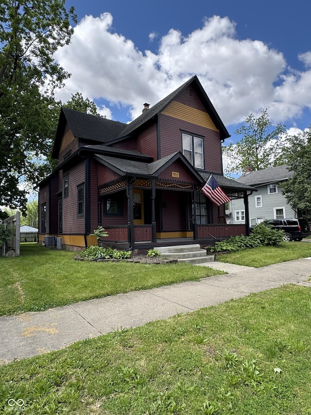 433 W Main St, Greenfield, IN 46140 - victorian home with covered porch, a front lawn, and a chimney