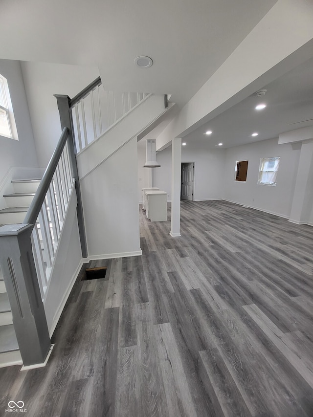 below grade area featuring baseboards, stairs, wood finished floors, and recessed lighting