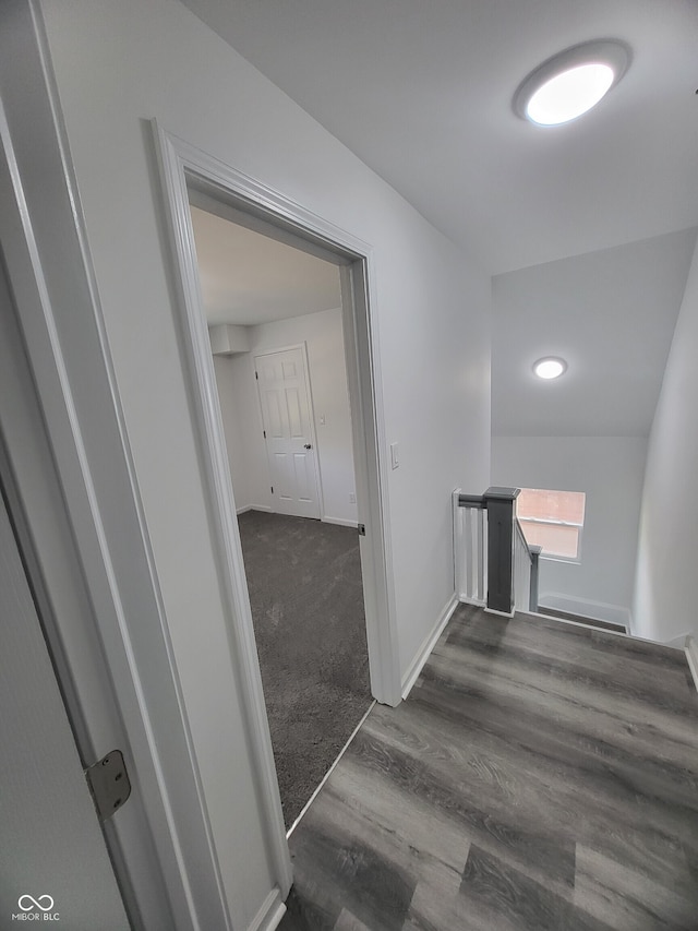 hall featuring an upstairs landing, dark wood-style floors, and baseboards
