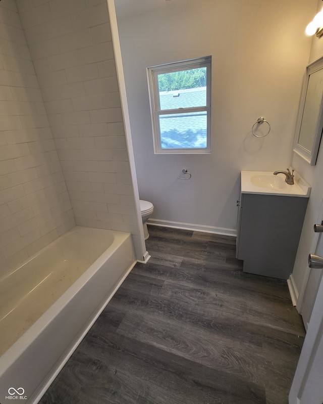 full bath with baseboards, wood finished floors, toilet, and vanity