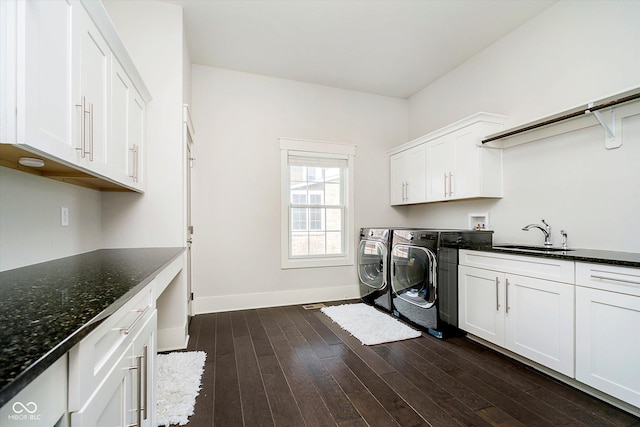 laundry area with washer and clothes dryer, a sink, cabinet space, baseboards, and dark wood-style floors