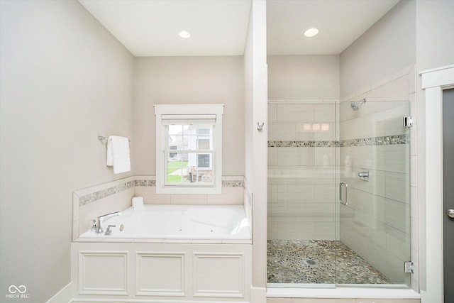 bathroom with a shower stall and a tub with jets