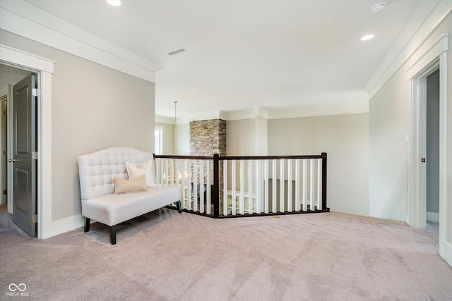 living area with crown molding, visible vents, carpet flooring, and an upstairs landing