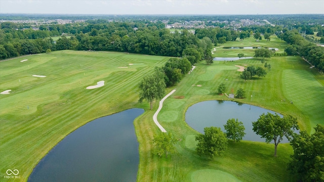 birds eye view of property with view of golf course and a water view