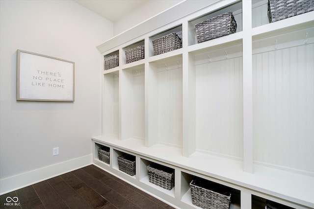 mudroom with dark wood finished floors and baseboards