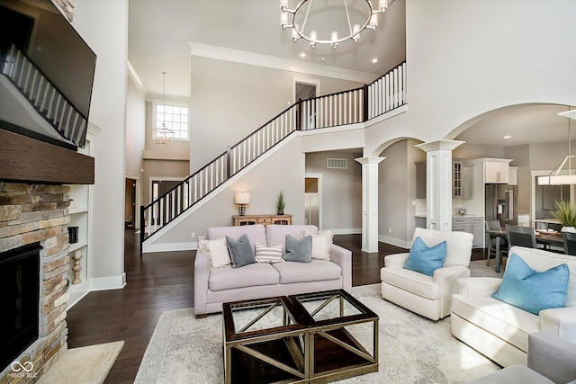 living room with a chandelier, a high ceiling, and decorative columns