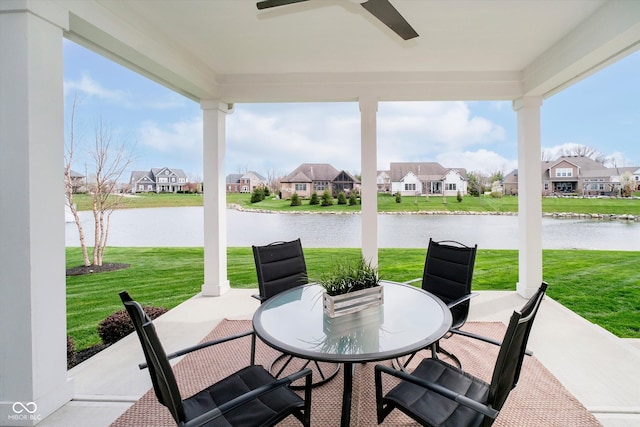 view of patio featuring a residential view, a water view, a ceiling fan, and outdoor dining space