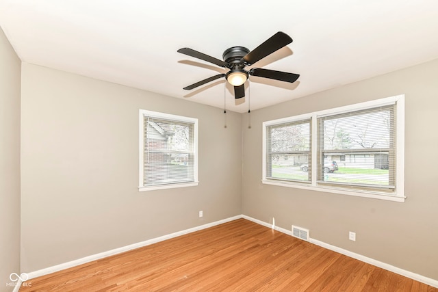 empty room featuring baseboards, visible vents, and a wealth of natural light