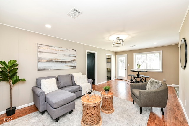 living area featuring visible vents, baseboards, recessed lighting, and wood finished floors