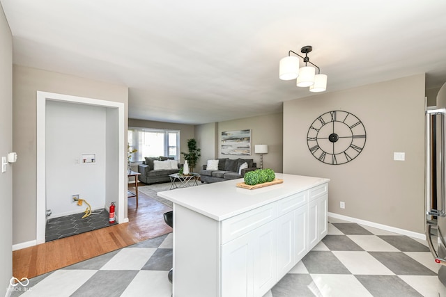 kitchen with pendant lighting, light floors, white cabinetry, a center island, and light countertops