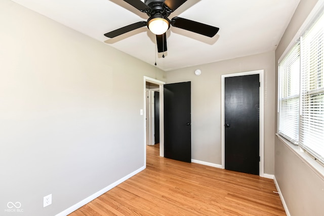 unfurnished bedroom featuring light wood-type flooring, baseboards, and ceiling fan