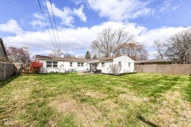 back of property with a yard, a fenced backyard, and a chimney