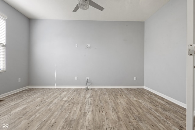 spare room featuring a ceiling fan, baseboards, and light wood-type flooring
