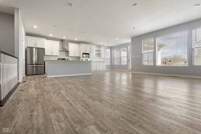 unfurnished living room with baseboards, light wood-style floors, and recessed lighting