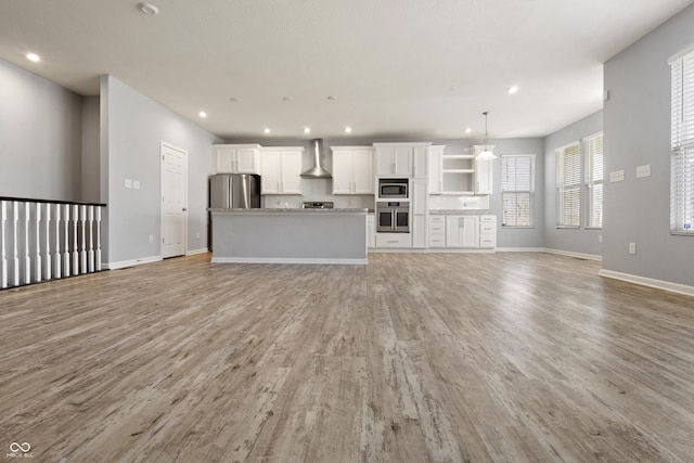 unfurnished living room featuring baseboards and light wood-type flooring