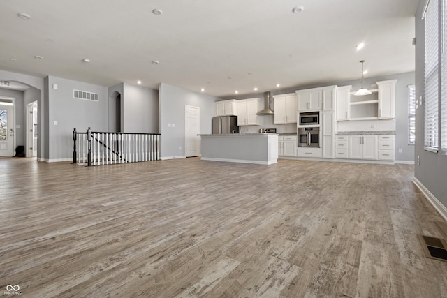 unfurnished living room featuring light wood-type flooring, recessed lighting, baseboards, and visible vents