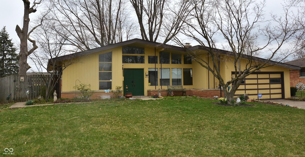 1936 Cunningham Rd, Indianapolis, IN 46224 - mid-century inspired home with a front yard, driveway, an attached garage, and fence