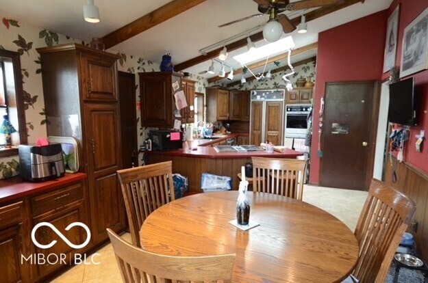 dining room featuring vaulted ceiling with beams and a ceiling fan