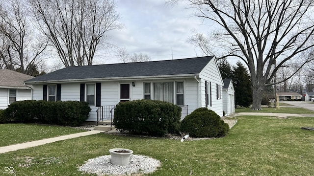 view of front of property with a front yard and a shingled roof