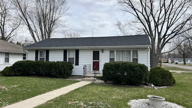 view of front of property featuring a front yard and roof with shingles