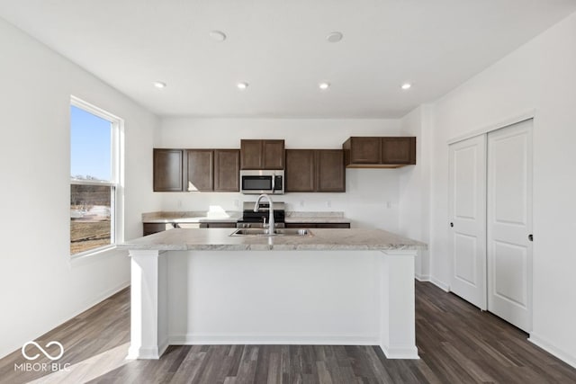 1924 White Oak Dr, Shelbyville, IN 46176 - kitchen with stainless steel microwave, an island with sink, a sink, and light countertops