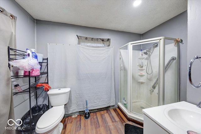 215 S Warman Ave, Indianapolis, IN 46222 - bathroom featuring toilet, a textured ceiling, vanity, wood finished floors, and a stall shower