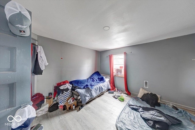 215 S Warman Ave, Indianapolis, IN 46222 - bedroom featuring visible vents, baseboards, wood finished floors, and a textured ceiling
