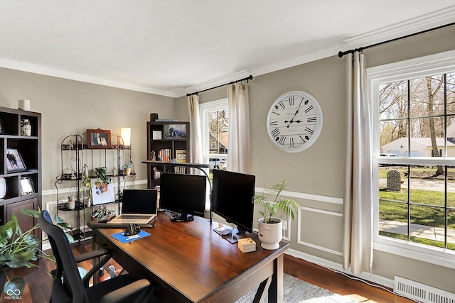office space with a wealth of natural light, visible vents, wood finished floors, and ornamental molding
