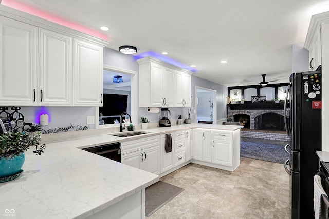 6820 W Forest Brook Dr, Fountaintown, IN 46130 - kitchen with a sink, a ceiling fan, a fireplace, black appliances, and white cabinetry