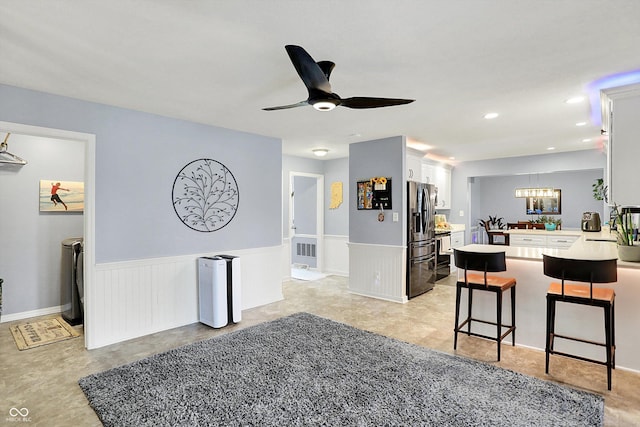 6820 W Forest Brook Dr, Fountaintown, IN 46130 - living area featuring a wainscoted wall, a chandelier, a ceiling fan, and recessed lighting