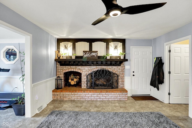 6820 W Forest Brook Dr, Fountaintown, IN 46130 - living room with ceiling fan, a brick fireplace, and wainscoting