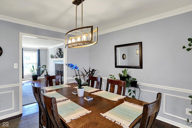 6820 W Forest Brook Dr, Fountaintown, IN 46130 - dining room featuring ornamental molding, dark wood-style floors, a brick fireplace, a chandelier, and baseboards