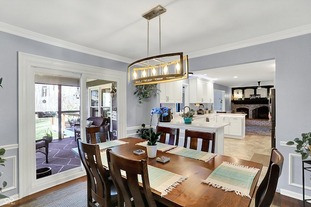6820 W Forest Brook Dr, Fountaintown, IN 46130 - dining room featuring crown molding, a fireplace, and a chandelier